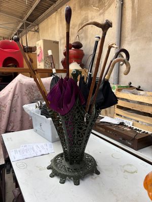 un vase contenant des parapluies et d'autres objets posés sur une table