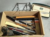 many pens and pencils in a box on the table