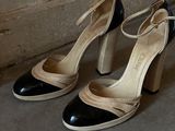 a pair of black and white high heeled shoes on the ground