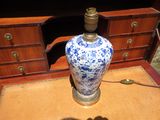 a blue and white vase sitting on a table next to a dresser