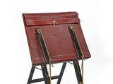 a red leather chair with two legs on a white background
