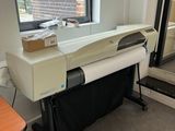 une photo d'une imprimante posée sur un bureau devant une fenêtre