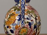 a vase with a floral design on it sitting on a table