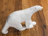 a white bear figurine sitting on a wooden floor