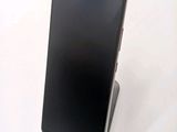 the back of a black cell phone sitting on top of a white table