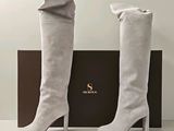 La femme porte une paire de bottes blanches à bout carré.
