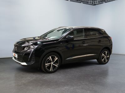 Un SUV noir est garé dans une grande pièce aux murs blancs.