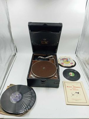 un vieux tourne-disque posé sur une table, à côté d'autres disques