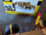 un tracteur en forme de chat et un bulldozer, tous deux en jouet, posés par terre
