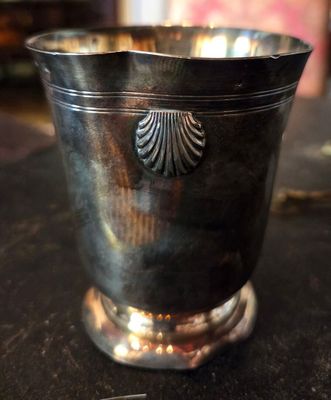 une coupe en argent posée sur une table, à côté d'une paire de ciseaux