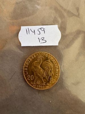 une pièce d'or posée sur la table, avec une étiquette indiquant son prix