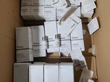 une boîte remplie de boîtes blanches, avec une paire de ciseaux posée dessus