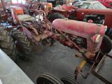 many old tractors in the garage of this building
