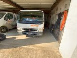 un camion blanc garé dans un garage à côté d'une camionnette blanche