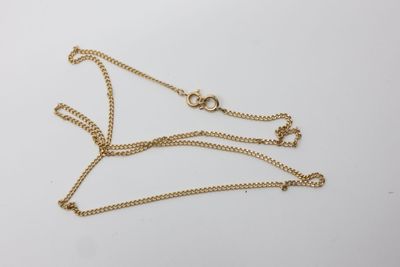 un collier en or muni d'une chaîne sur laquelle sont fixés deux anneaux