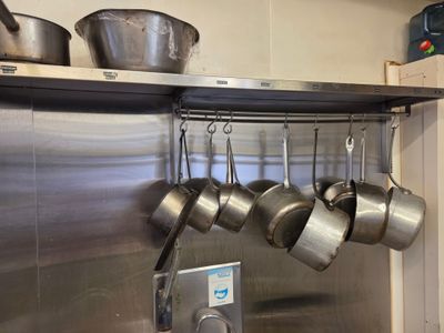 casseroles et poêles accrochées au mur de la cuisine