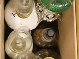 une boîte remplie de bouteilles et une lampe posée par terre