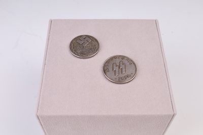 deux pièces posées dans une boîte sur une surface blanche