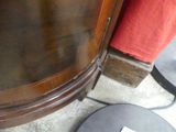 a small black table with a paper on it next to a brown cabinet