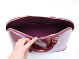 someone is holding a purple purse with a pink handle