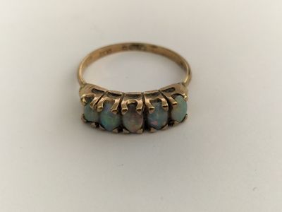 a close up of a gold ring with three oplite stones