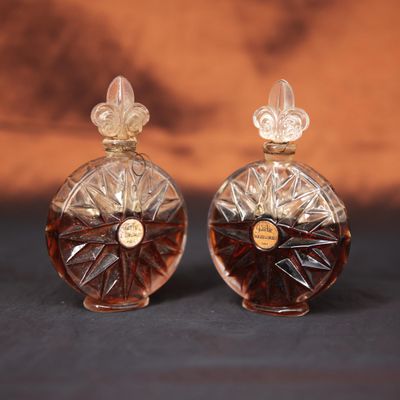 deux flacons de parfum posés l'un à côté de l'autre sur une table