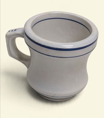 a white cup with a blue stripe on it