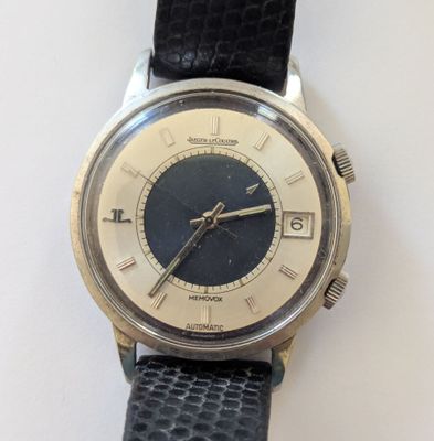 une montre argentée et noire avec un bracelet noir