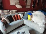 un salon avec un canapé, un fauteuil, un pouf et une table basse