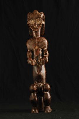 une statue en bois représentant un homme tenant un bébé dans ses bras