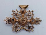 une photo d'une broche en forme de flocon de neige en or et diamants noirs