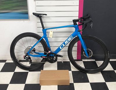 a blue bike that is sitting on a black and white checkered floor