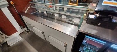 a counter with a glass case and a television on it