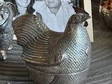 a photo of a man and a woman sitting next to a silver chicken