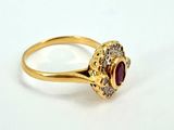 an image of a close up of a gold ring with a red stone