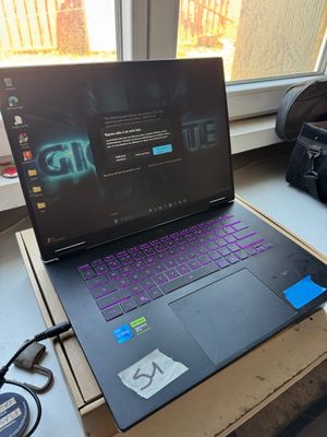un ordinateur portable posé sur une table près d'une fenêtre