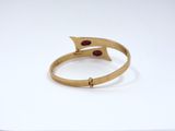 a close up of a gold ring with a red stone on it