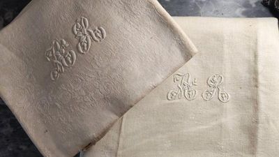 deux serviettes ornées de monogrammes posées sur une table