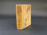 a close up of a book on a table with a black background