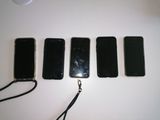 Quatre téléphones portables sont alignés sur une table