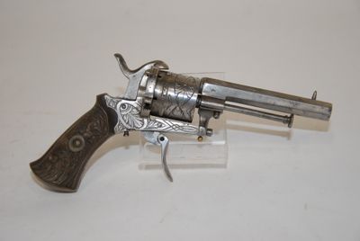 a silver revolver with a wooden handle on a white surface