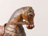 statue of a wooden horse with a bridle on it ' s head