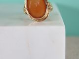 an image of a gold ring with a carnel stone in the center