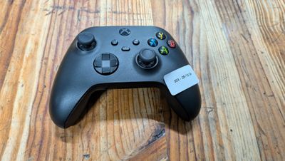 un gros plan d'une manette de jeu posée sur une table en bois