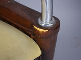 a close up of a wooden chair with a metal handle