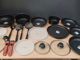 many pots and pans sitting on a table with utensils