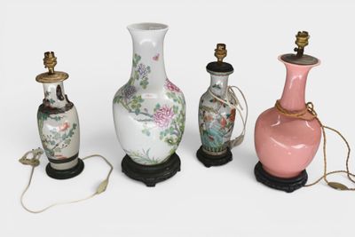 three vases and a lamp on a table with a white background