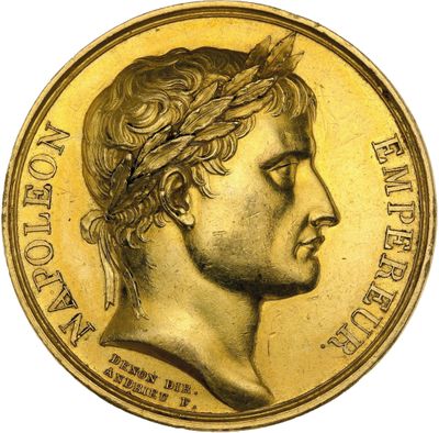 a close up of a gold coin with a man ' s face