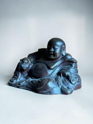 buddha figurine sitting on a white surface with a white background