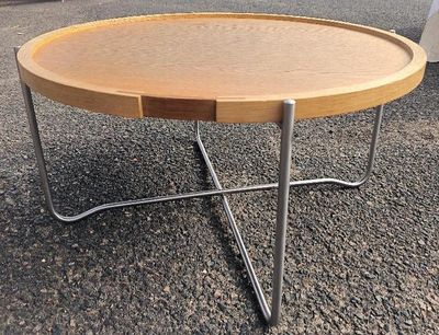 une table en bois avec des pieds en métal, sur laquelle est posé un plateau en bois